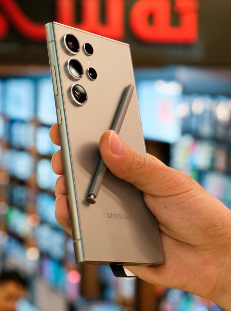 a person holding a silver cell phone in their hand